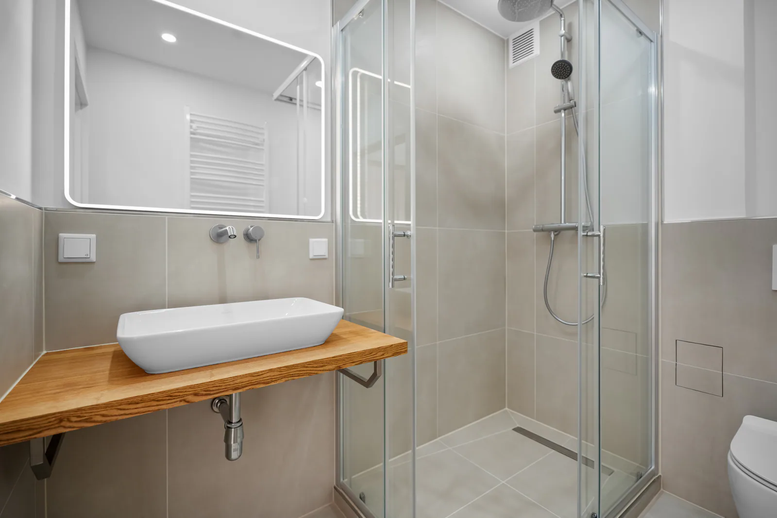 Kernsaniertes Badezimmer mit Dusche und Waschtisch auf Holzkonsole