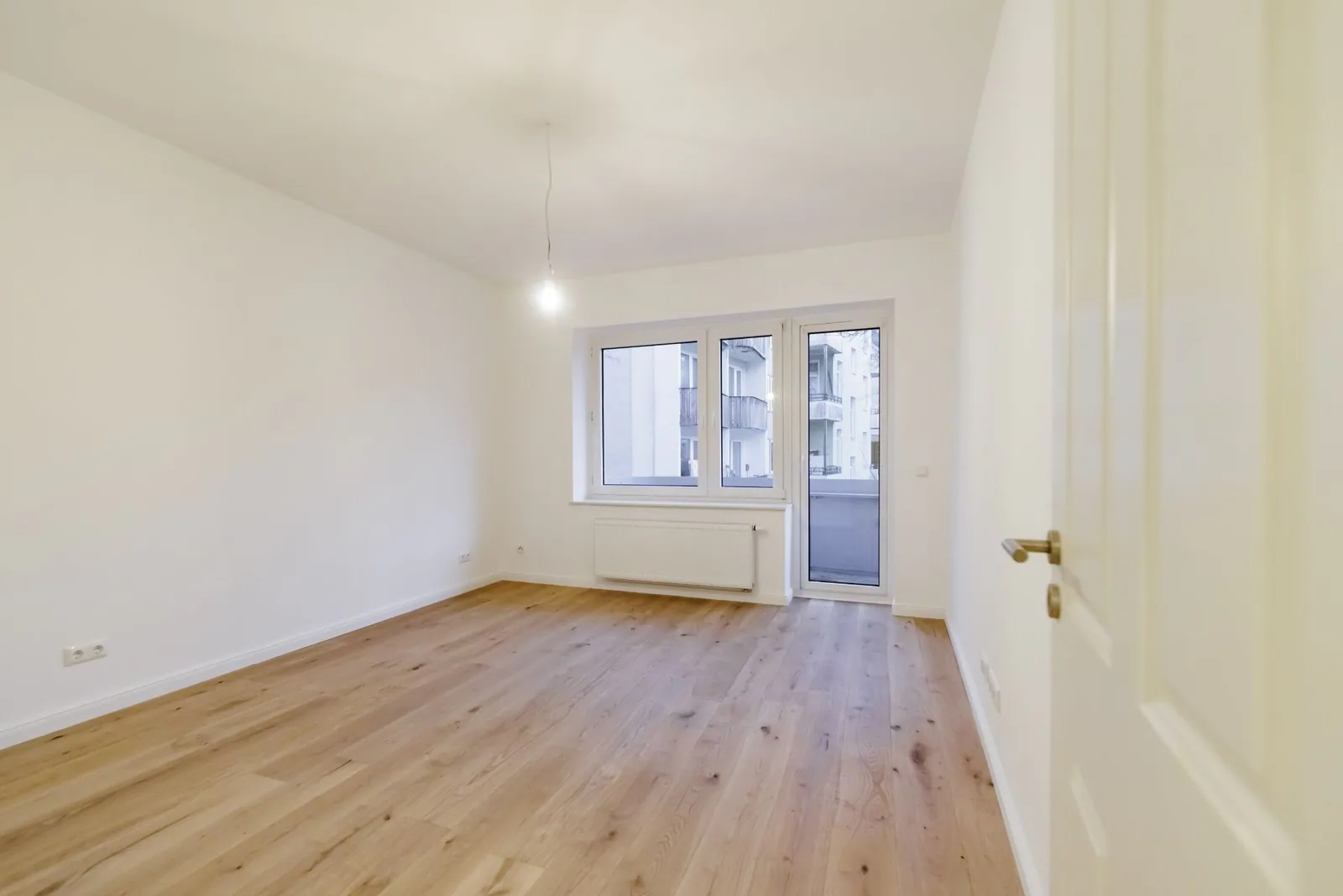 Kernsanierter Wohnraum mit Parkettboden und Balkontuer